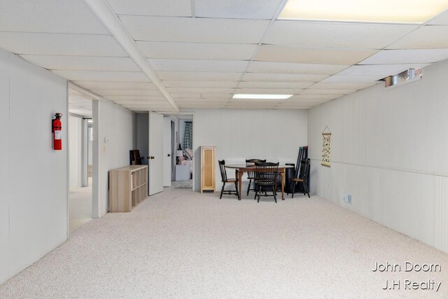 below grade area featuring carpet floors and a drop ceiling