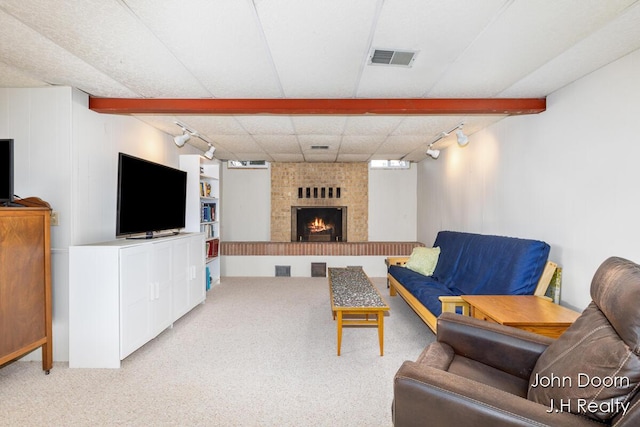 carpeted living room with rail lighting and a fireplace