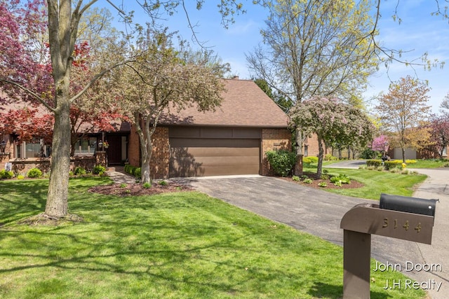 view of front of house featuring brick siding, asphalt driveway, a garage, and a front lawn
