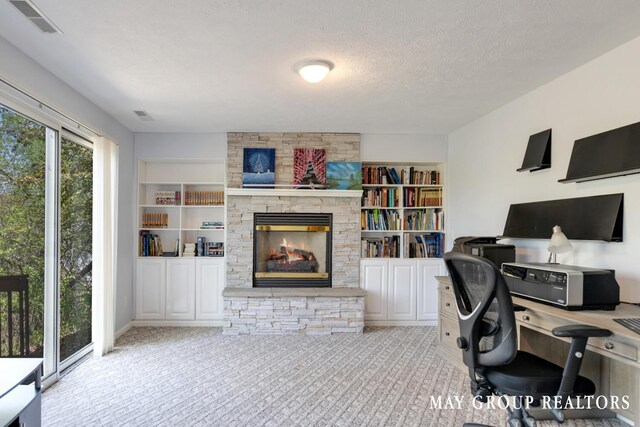 3729 Windshire Dr SE, Grand Rapids, MI 49546 - home office featuring a stone fireplace, a textured ceiling, carpet floors, and built in features