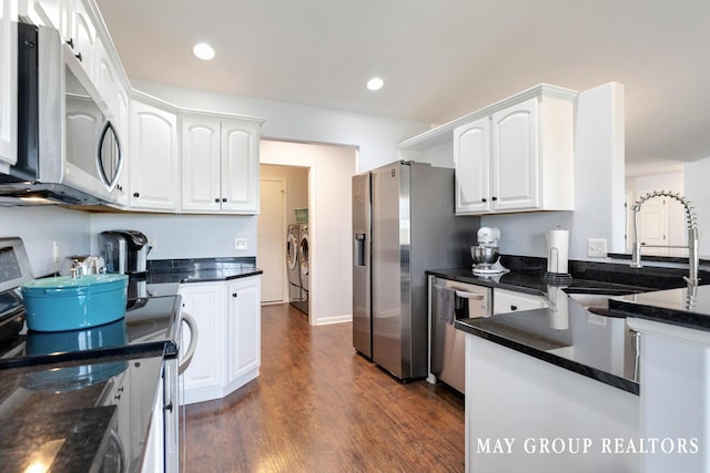 3729 Windshire Dr SE, Grand Rapids, MI 49546 - kitchen featuring washing machine and clothes dryer, appliances with stainless steel finishes, a sink, white cabinetry, and dark wood-type flooring
