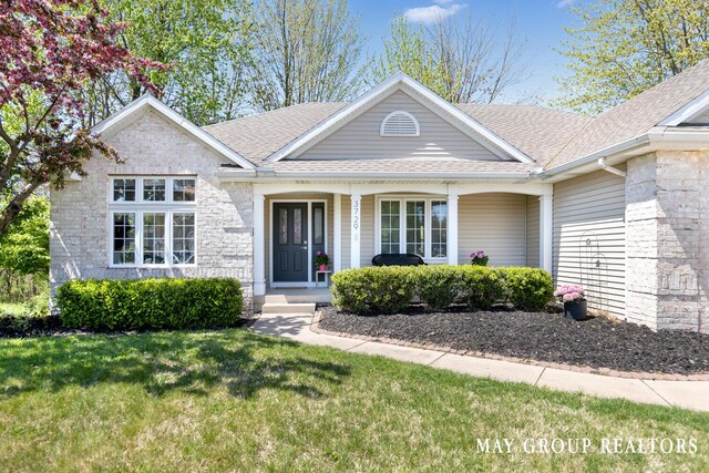 3729 Windshire Dr SE, Grand Rapids, MI 49546 - single story home featuring roof with shingles, a front lawn, covered porch, and stone siding