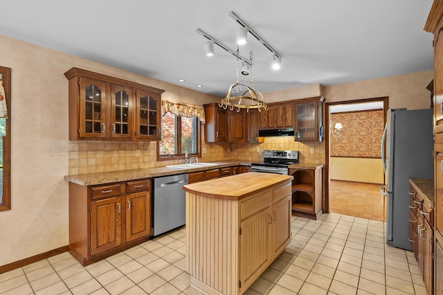 275 S Bluffwood Ter, Saint Joseph, MI 49085 - kitchen featuring stainless steel appliances, a sink, butcher block countertops, light tile patterned floors, and tasteful backsplash