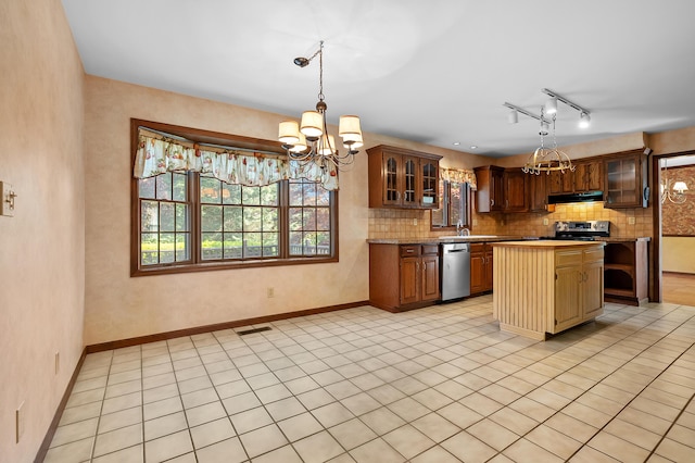 275 S Bluffwood Ter, Saint Joseph, MI 49085 - kitchen featuring a chandelier, appliances with stainless steel finishes, under cabinet range hood, backsplash, and light countertops