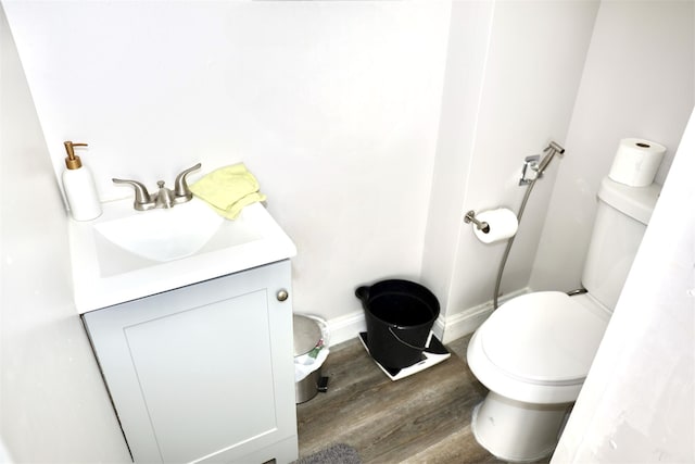 6131 S Mohawk Ave, Ypsilanti, MI 48197 - bathroom with wood finished floors, toilet, vanity, and baseboards