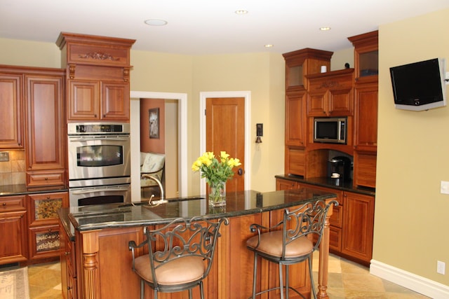 60 Timber Ridge Ct, Milan, MI 48160 - kitchen featuring stainless steel appliances, a kitchen island with sink, a kitchen bar, recessed lighting, and dark stone countertops