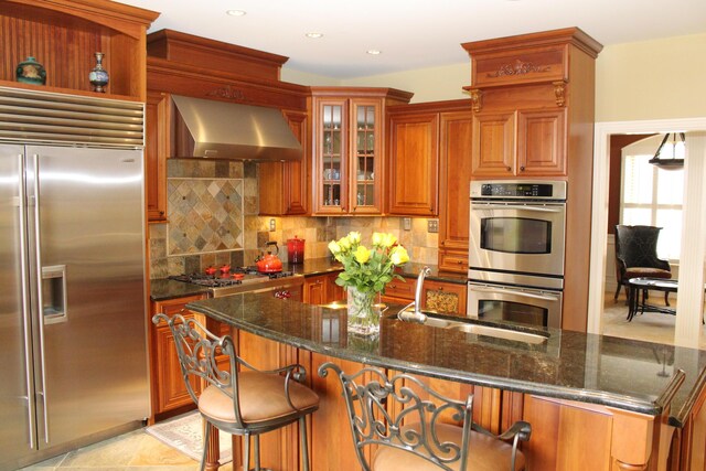 60 Timber Ridge Ct, Milan, MI 48160 - kitchen featuring stainless steel appliances, wall chimney range hood, decorative backsplash, brown cabinetry, and recessed lighting