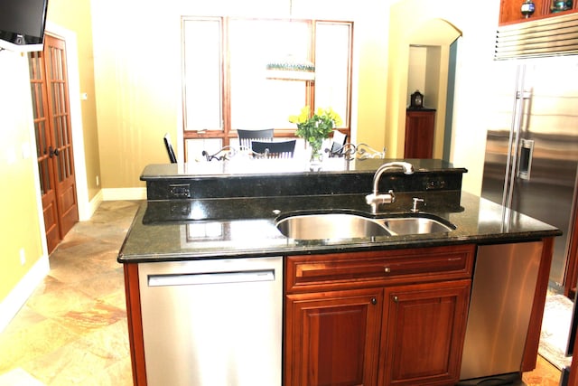 60 Timber Ridge Ct, Milan, MI 48160 - kitchen with appliances with stainless steel finishes, reddish brown cabinets, a center island with sink, and dark stone countertops