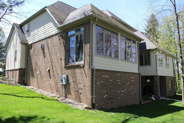 60 Timber Ridge Ct, Milan, MI 48160 - view of home's exterior with brick siding, a lawn, a sunroom, and a shingled roof