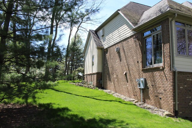 60 Timber Ridge Ct, Milan, MI 48160 - view of property exterior with brick siding, a yard, and roof with shingles