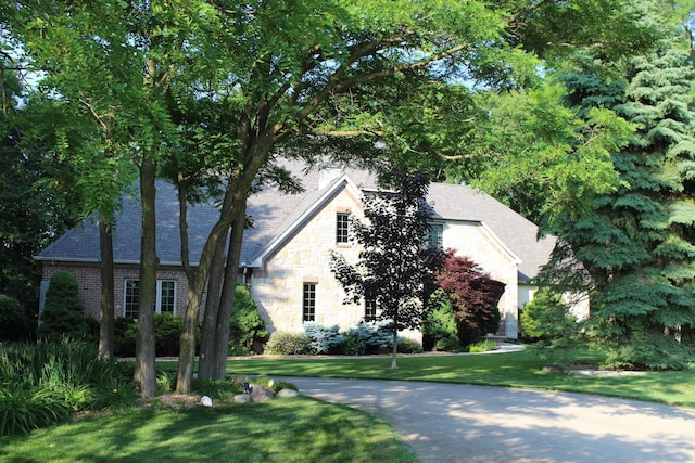 60 Timber Ridge Ct, Milan, MI 48160 - view of side of property featuring stone siding, a lawn, and brick siding