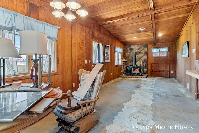 12345 92nd St SE, Alto, MI 49302 - interior space with a wood stove, wood walls, lofted ceiling, wood ceiling, and unfinished concrete floors