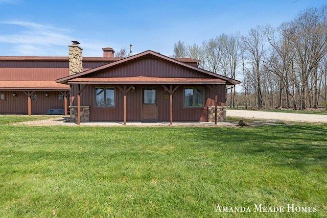 12345 92nd St SE, Alto, MI 49302 - view of front of property featuring a patio, a shingled roof, a front yard, and a chimney