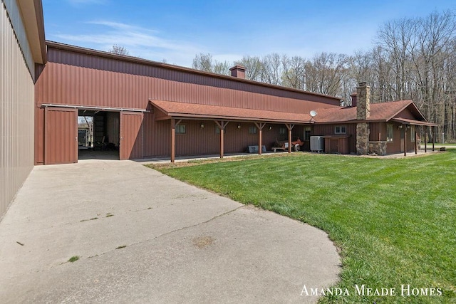 12345 92nd St SE, Alto, MI 49302 - exterior space with a lawn, concrete driveway, a chimney, and central AC unit