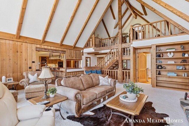 12345 92nd St SE, Alto, MI 49302 - living area featuring carpet floors, wood walls, stairs, beamed ceiling, and high vaulted ceiling
