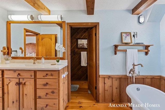 12345 92nd St SE, Alto, MI 49302 - full bath featuring a textured ceiling, a freestanding tub, beam ceiling, wood finished floors, and wooden walls