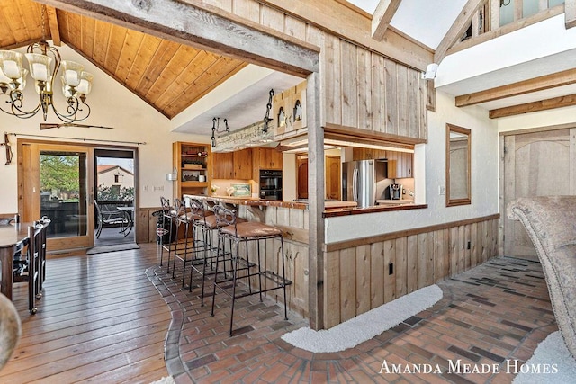 12345 92nd St SE, Alto, MI 49302 - kitchen featuring freestanding refrigerator, dobule oven black, a notable chandelier, and beam ceiling