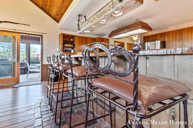 12345 92nd St SE, Alto, MI 49302 - dining room with wainscoting, wood walls, wood finished floors, and lofted ceiling