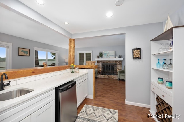 1266 E 88th St, Newaygo, MI 49337 - kitchen featuring stainless steel dishwasher, a sink, light stone countertops, open floor plan, and dark wood finished floors