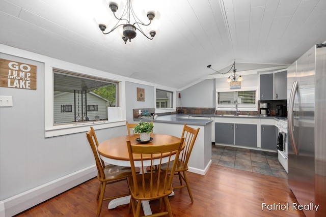 1266 E 88th St, Newaygo, MI 49337 - dining space featuring a chandelier, dark wood-style floors, lofted ceiling, and baseboards