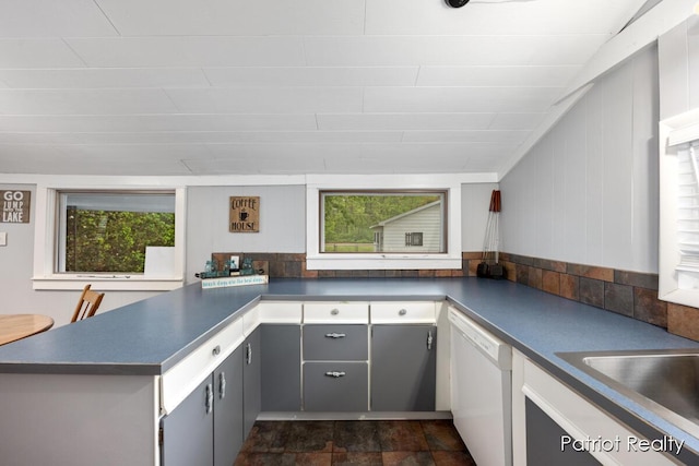 1266 E 88th St, Newaygo, MI 49337 - kitchen with white dishwasher, a peninsula, dark countertops, gray cabinetry, and a sink