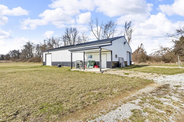 7499 Mathews Rd, Spring Arbor, MI 49283 - rear view of property with a garage, an outdoor structure, and a lawn