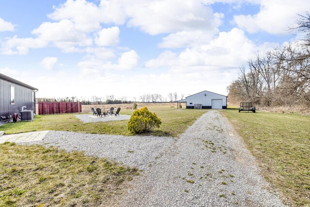 7499 Mathews Rd, Spring Arbor, MI 49283 - view of yard featuring a garage, central air condition unit, fence, an outdoor structure, and gravel driveway