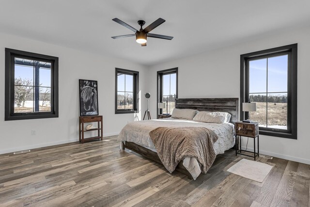 7499 Mathews Rd, Spring Arbor, MI 49283 - bedroom featuring baseboards, visible vents, multiple windows, and wood finished floors