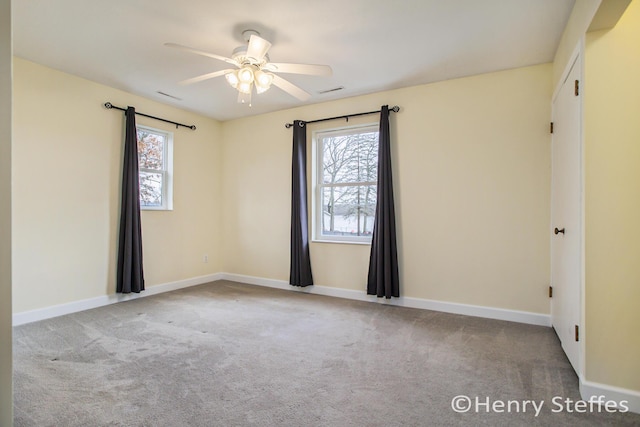spare room featuring carpet floors, plenty of natural light, and ceiling fan
