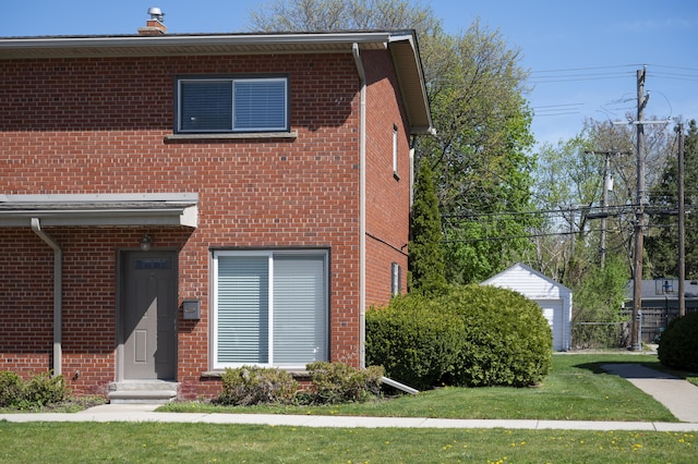 view of front facade with brick siding and a front lawn