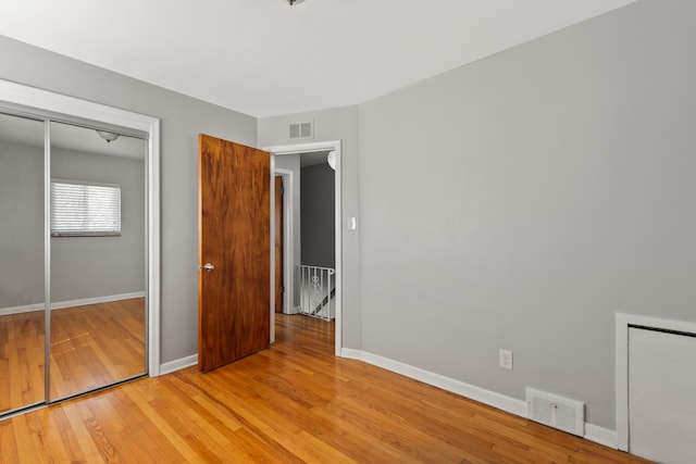 unfurnished bedroom featuring visible vents, light wood-style floors, and baseboards