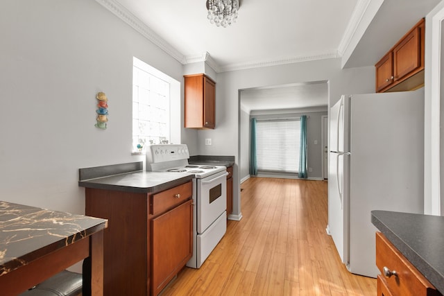 kitchen with white appliances, dark countertops, plenty of natural light, and brown cabinetry
