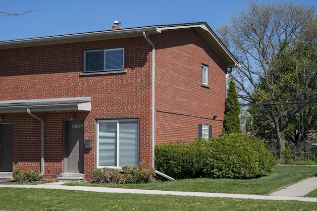 view of front of home featuring brick siding and a front lawn