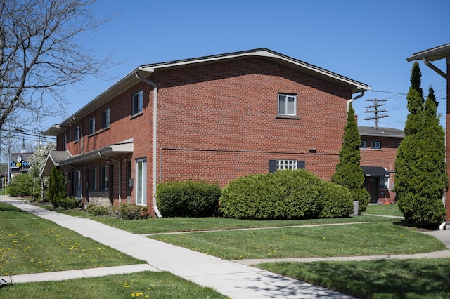 view of home's exterior featuring a lawn and brick siding