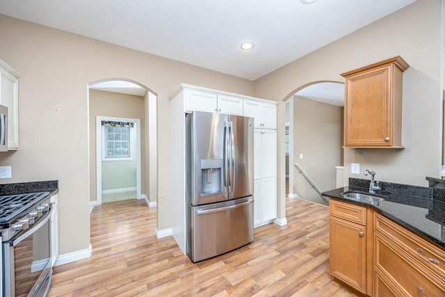 18559 Kreig Dr, Big Rapids, MI 49307 - kitchen with a sink, arched walkways, stainless steel appliances, and light wood-type flooring