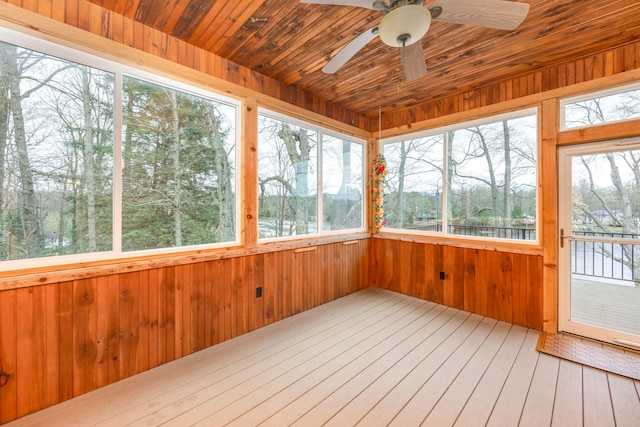 18559 Kreig Dr, Big Rapids, MI 49307 - unfurnished sunroom featuring wooden walls, a water view, and wood-type flooring