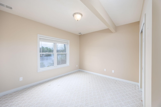 18559 Kreig Dr, Big Rapids, MI 49307 - unfurnished room with baseboards, light colored carpet, beam ceiling, and visible vents