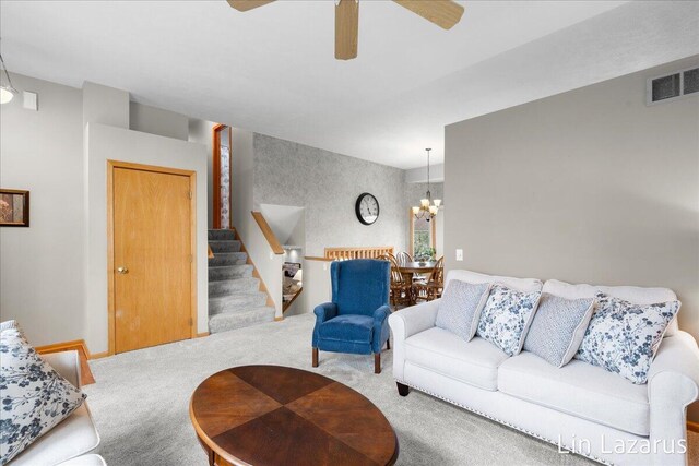 6332 Rush Creek Ct, Hudsonville, MI 49426 - living area featuring carpet flooring, visible vents, stairs, and ceiling fan with notable chandelier