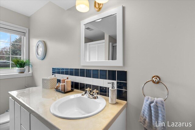 6332 Rush Creek Ct, Hudsonville, MI 49426 - bathroom with vanity, decorative backsplash, toilet, and visible vents