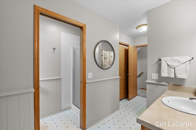 6332 Rush Creek Ct, Hudsonville, MI 49426 - bathroom with tile patterned floors, a wainscoted wall, and curtained shower