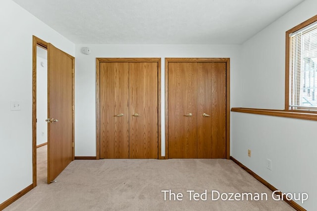 45 Trillium Ct, Holland, MI 49423 - unfurnished bedroom with baseboards, carpet, and two closets