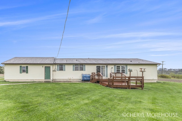 rear view of property featuring a wooden deck and a yard
