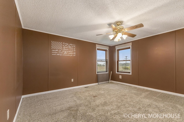 carpeted spare room featuring crown molding, a ceiling fan, and a textured ceiling