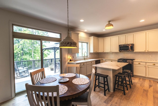 270 Fairway View Dr, Oxford, MI 48371 - kitchen with stainless steel appliances, decorative backsplash, a breakfast bar, light wood-style floors, and recessed lighting