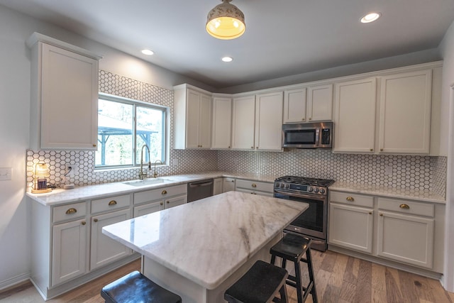 270 Fairway View Dr, Oxford, MI 48371 - kitchen featuring appliances with stainless steel finishes, a kitchen bar, wood finished floors, backsplash, and recessed lighting