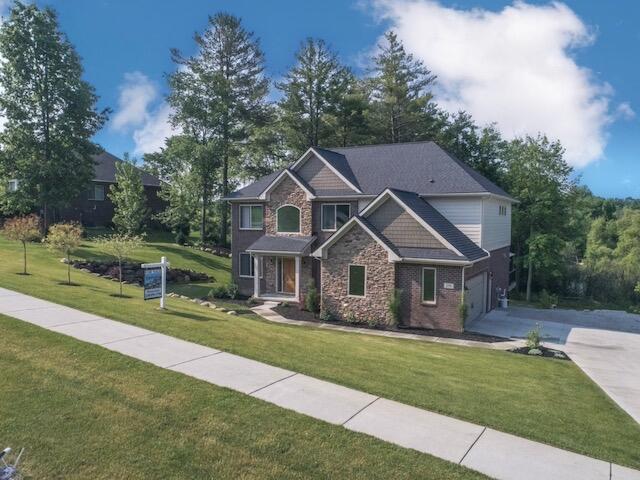270 Fairway View Dr, Oxford, MI 48371 - craftsman-style house with driveway, an attached garage, a front yard, and brick siding