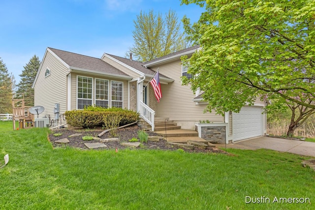 split level home featuring a front yard, concrete driveway, and a garage