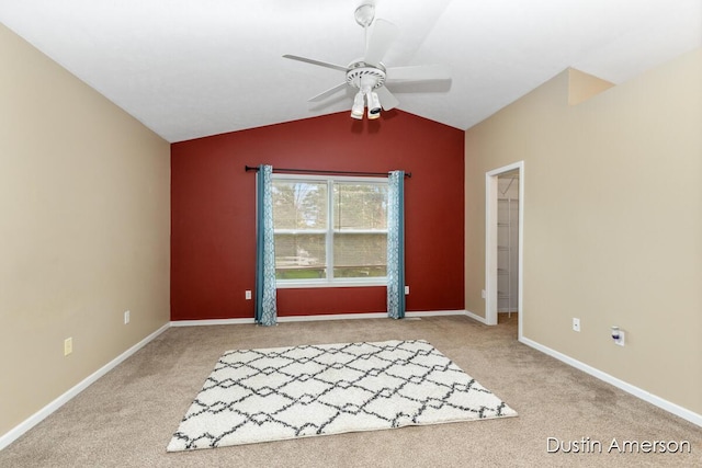 spare room with carpet floors, a ceiling fan, lofted ceiling, and baseboards