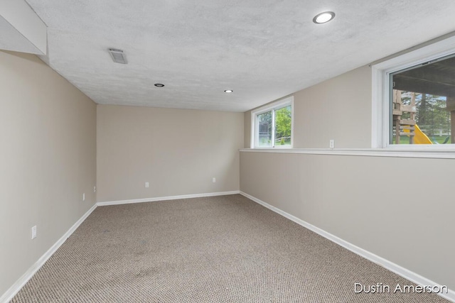 empty room featuring carpet flooring, baseboards, and recessed lighting