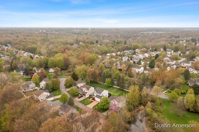 aerial overview of property's location featuring nearby suburban area and a heavily wooded area